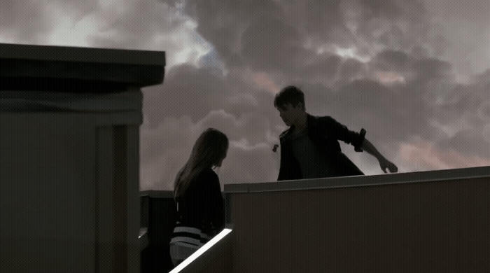 a man and a woman standing on top of a roof