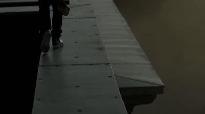 a person standing on a ledge with a skateboard