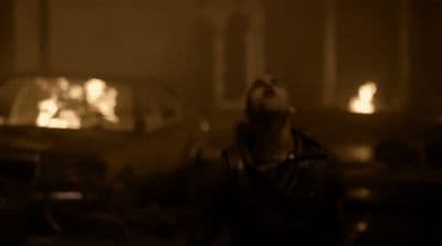 a blurry image of a man standing in front of a car
