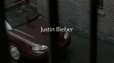 a red car behind bars in front of a brick wall
