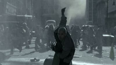 a man holding a suitcase in the middle of a street