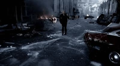 a man walking down a street next to parked cars