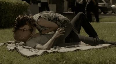 a man laying on top of a lush green field