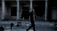 a man walking across a street in front of a building