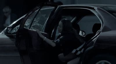 a woman sitting in the driver's seat of a car