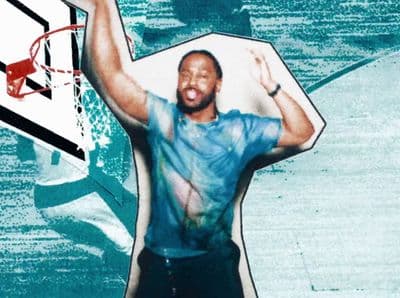 a man holding a basketball in front of a basketball hoop