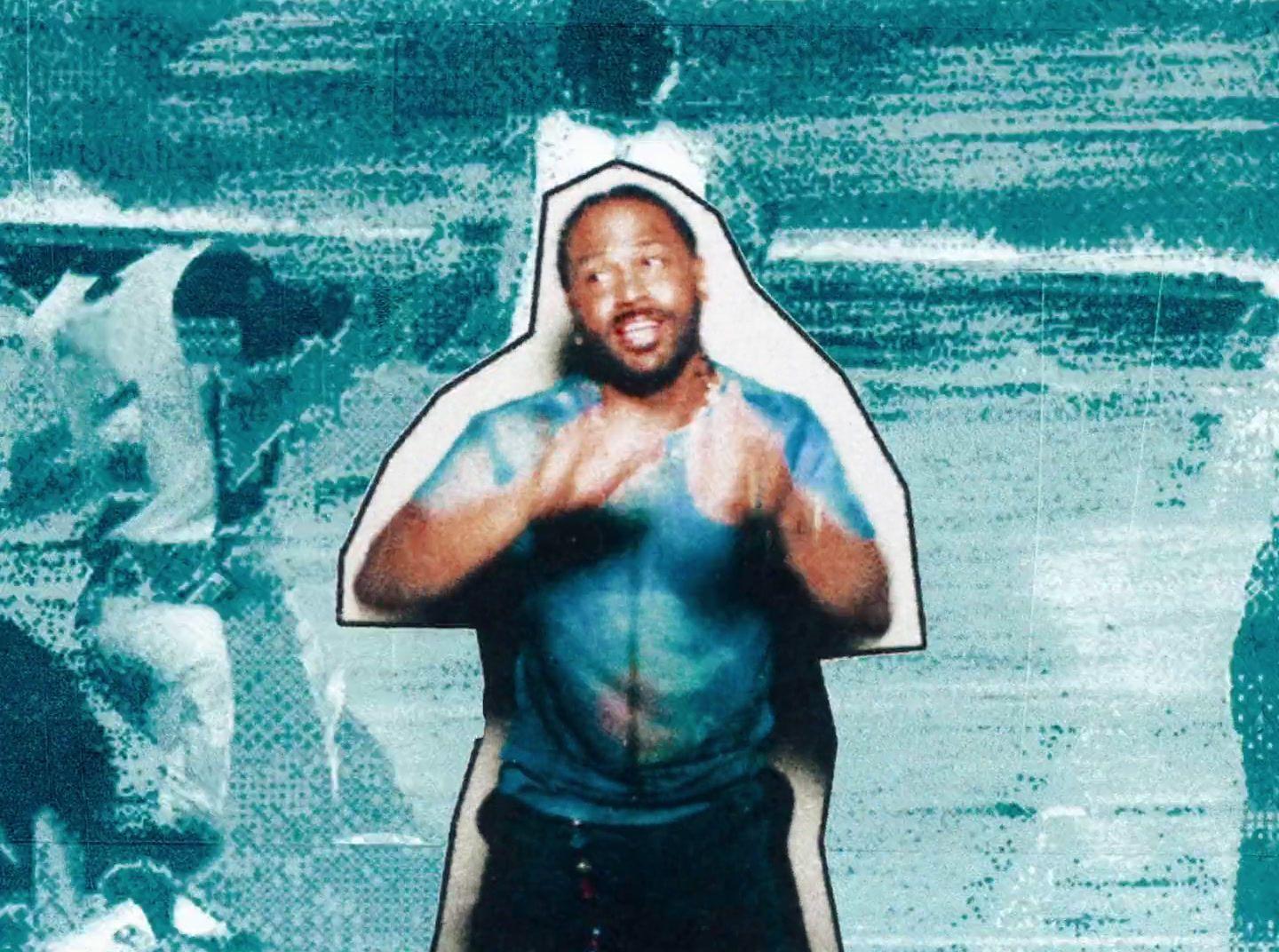 a man in a blue shirt and black shorts standing in front of a painting of