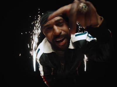 a man in a black and white jacket holding a sparkler