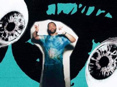 a man standing in front of a pair of large eyeballs