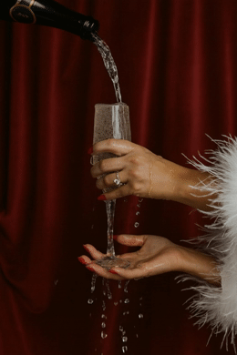 a woman pouring a glass of wine into a wine glass