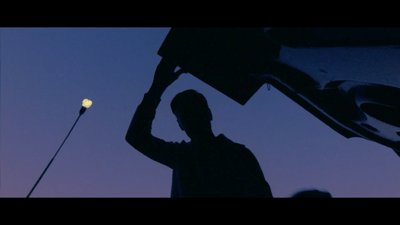 a silhouette of a man holding a street light