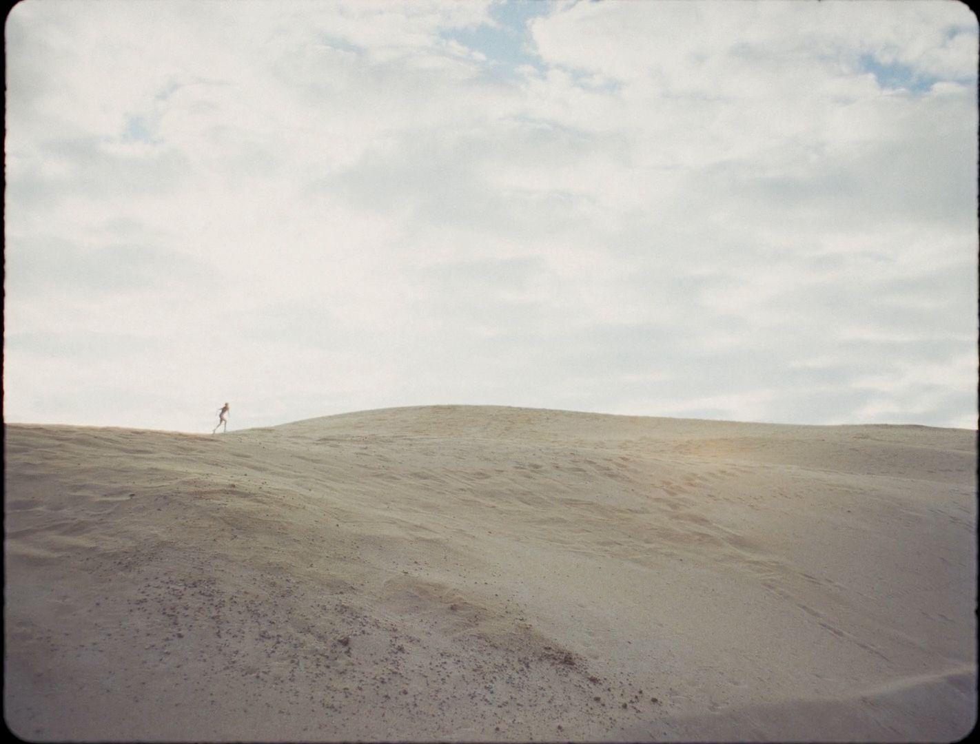 a person standing on top of a sandy hill