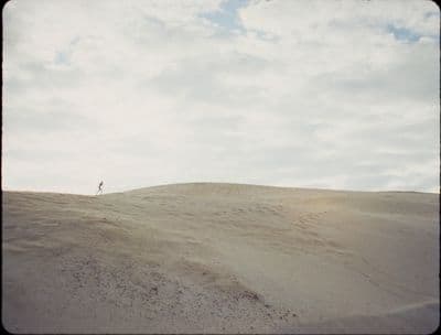 a person standing on top of a sandy hill