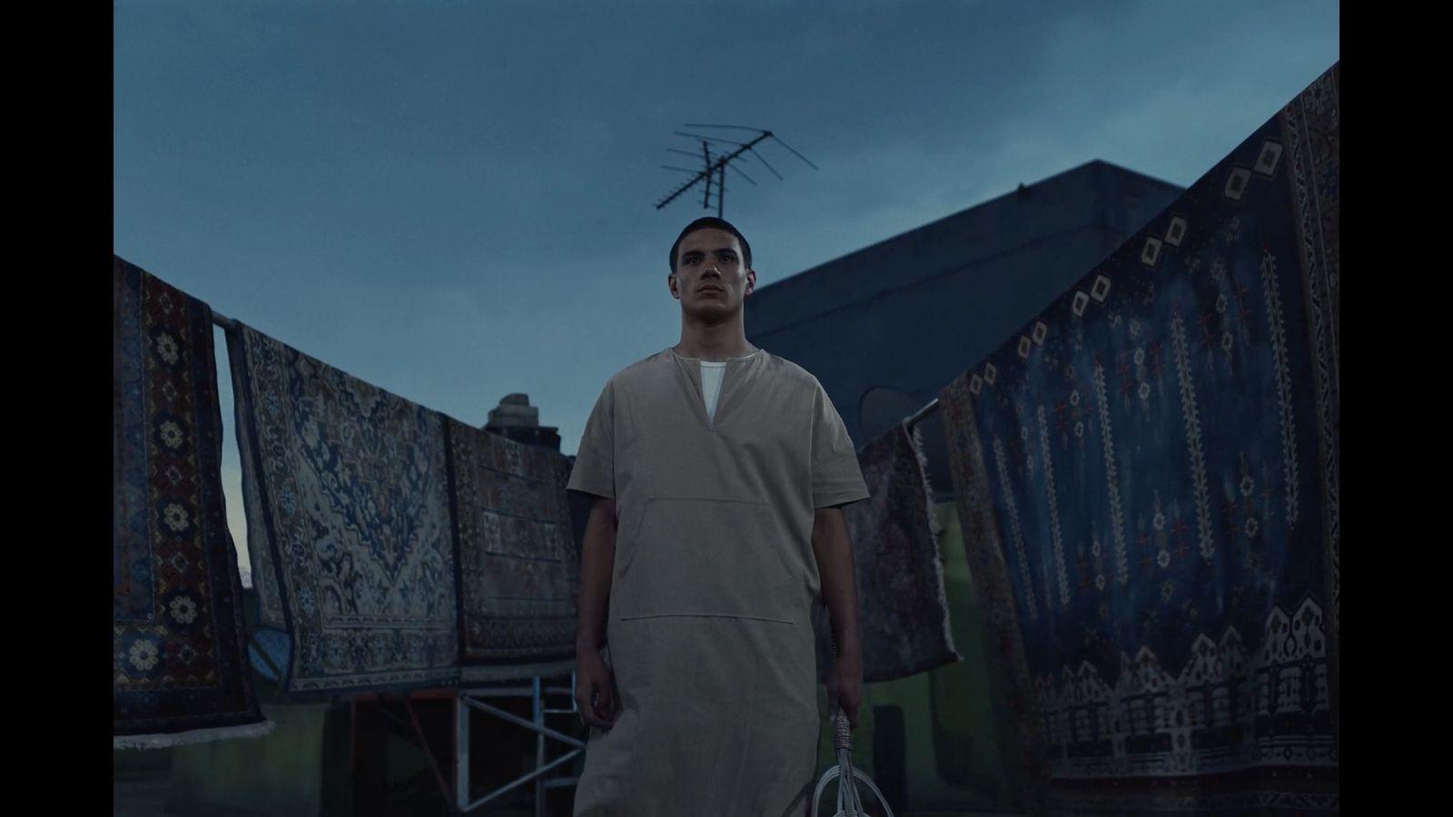 a man with a tennis racket standing in front of a building