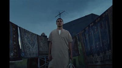 a man with a tennis racket standing in front of a building