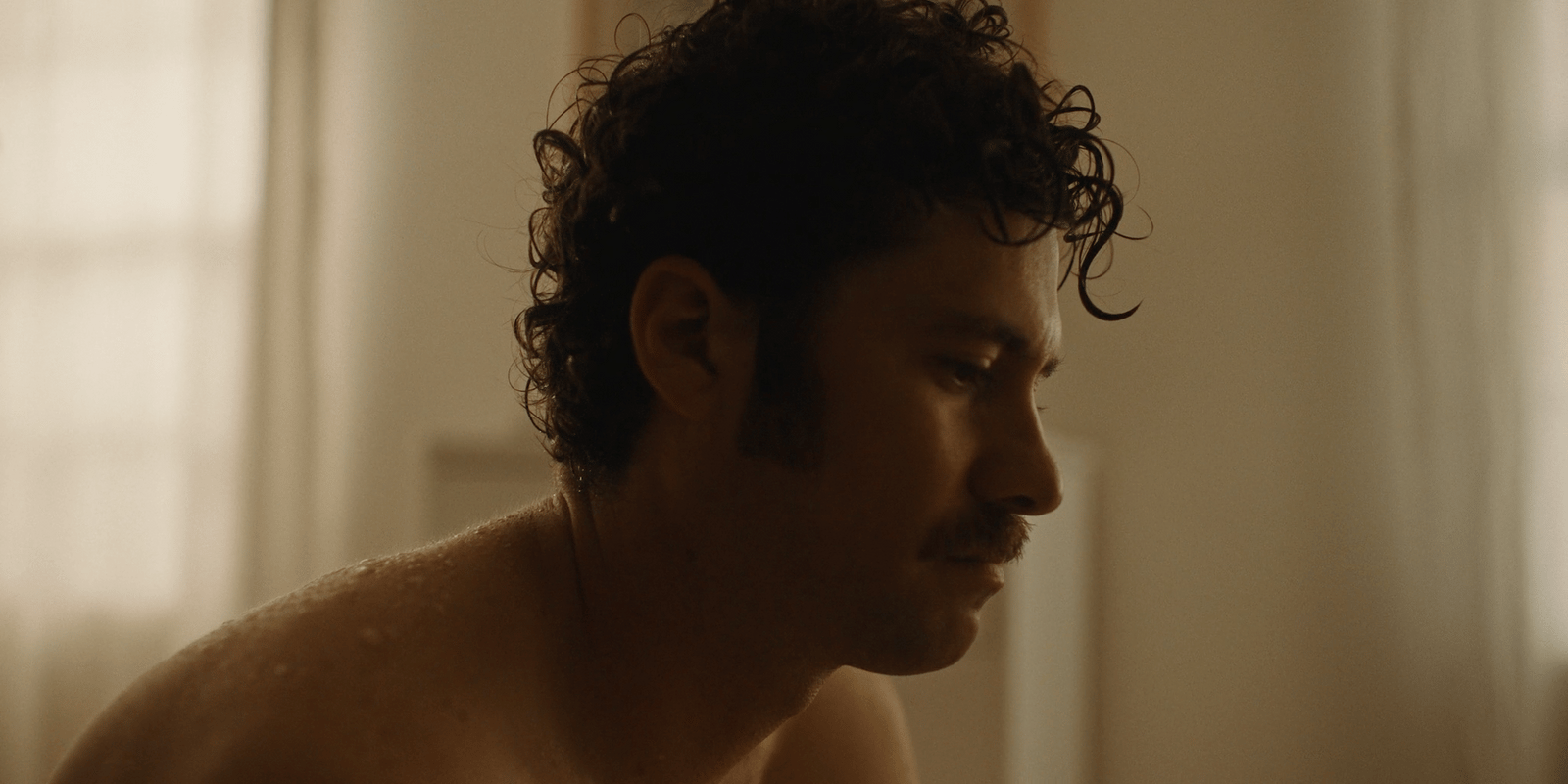 a shirtless man with curly hair and no shirt on