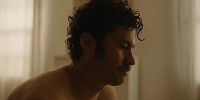a shirtless man with curly hair and no shirt on