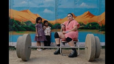 a woman sitting on top of a wheel chair next to two little girls
