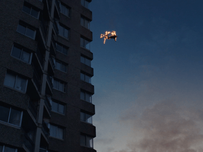 a plane flying in the sky over a tall building