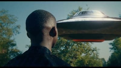 a man looking at a flying object in the sky