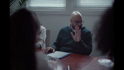 a man sitting at a table in front of a laptop