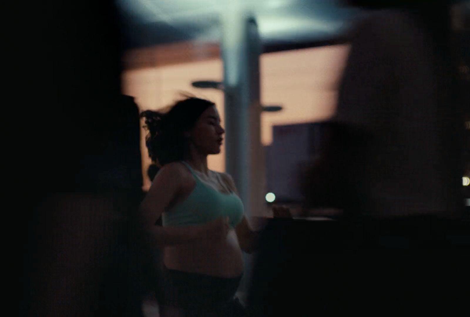 a woman standing in a dark room next to a window