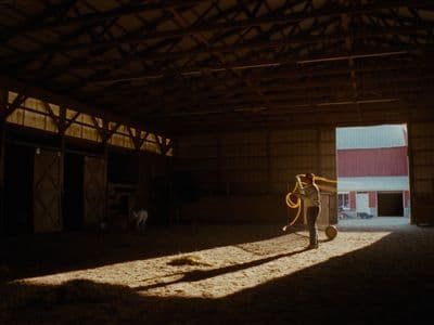 a person standing in a barn with a hose