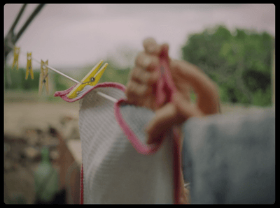 a hand holding a string of clothes on a clothes line