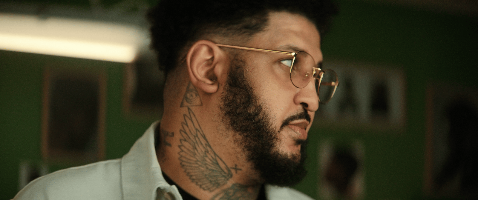 a man with a beard and glasses looking off into the distance