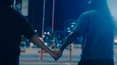 a couple of people holding hands on a street