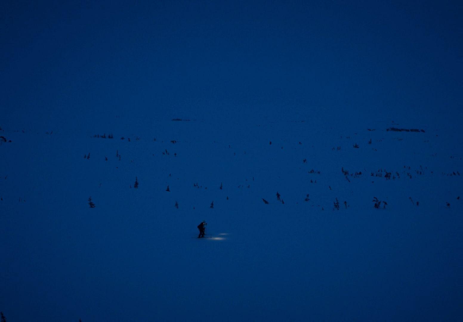 a person standing in the snow at night