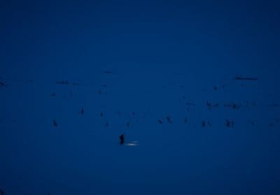 a person standing in the snow at night