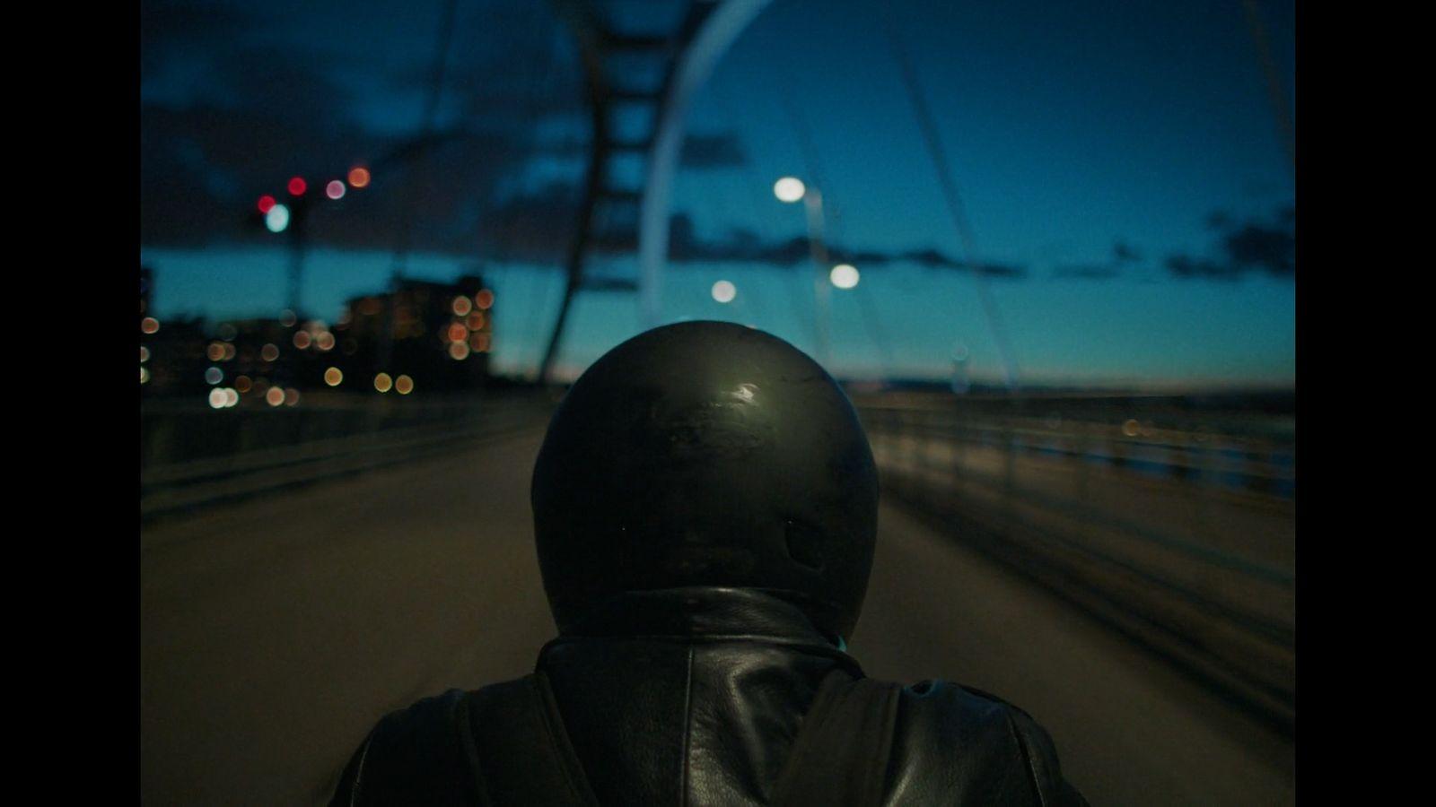 a person wearing a black leather jacket and helmet