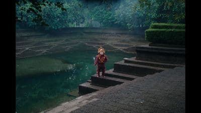 a young boy standing on steps in front of a body of water