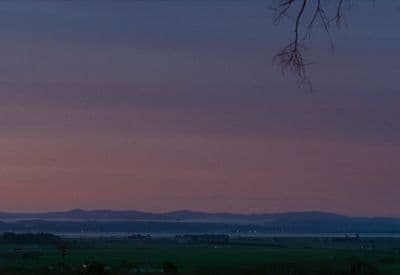 a view of a field with mountains in the distance