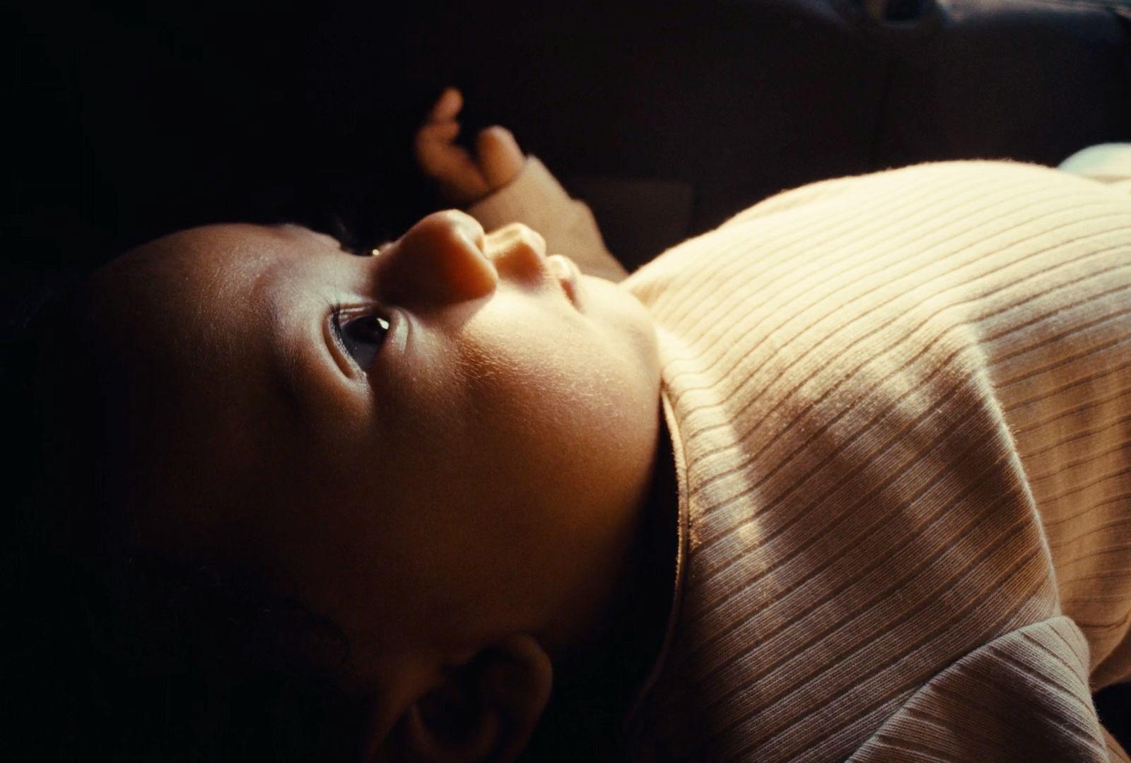 a close up of a baby laying on a bed