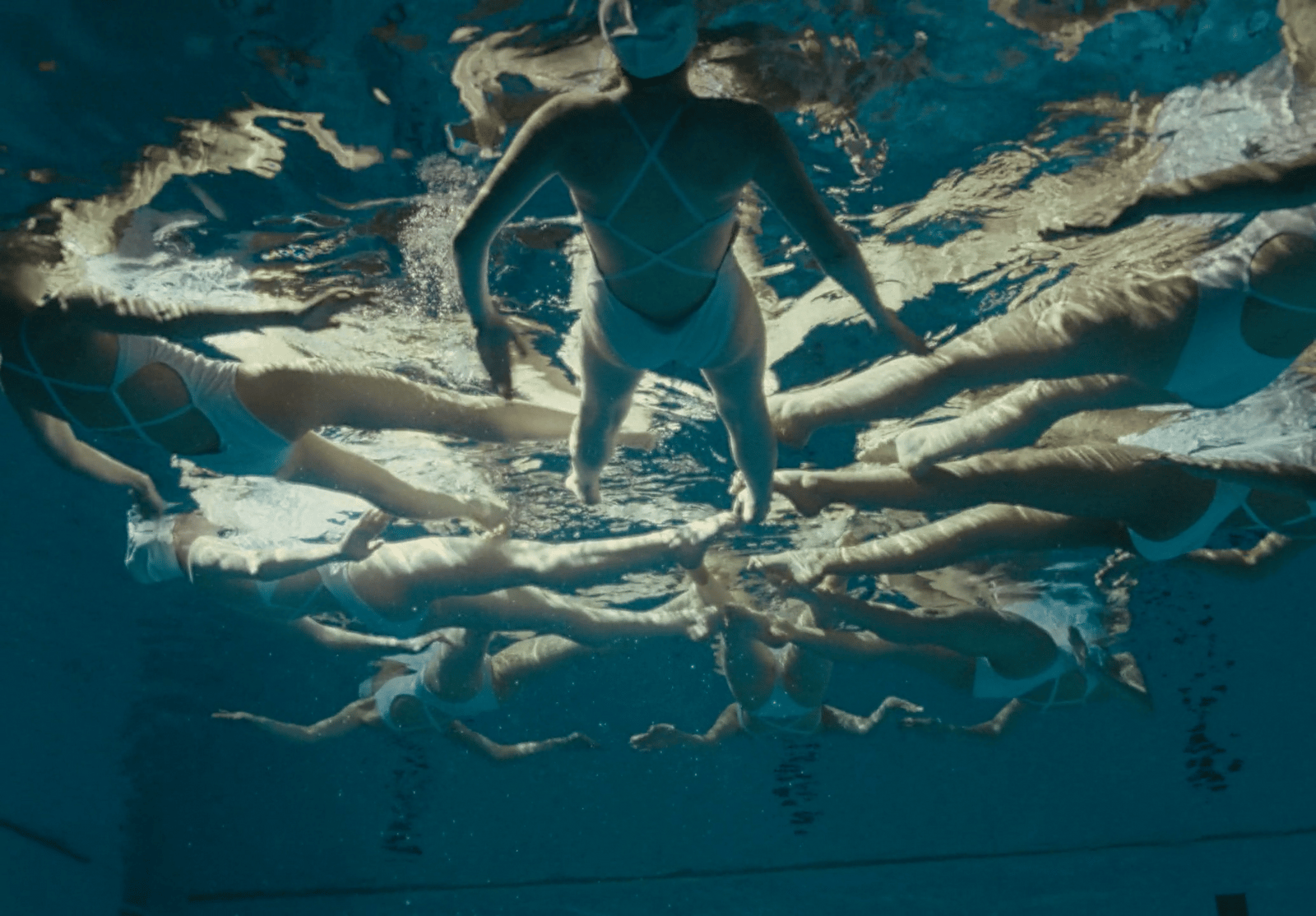a man is swimming in a pool full of people