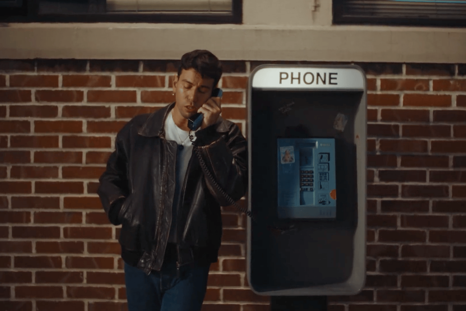 a man standing in front of a phone booth