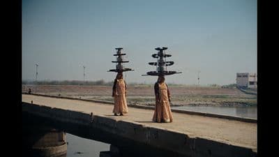a couple of statues sitting on top of a bridge