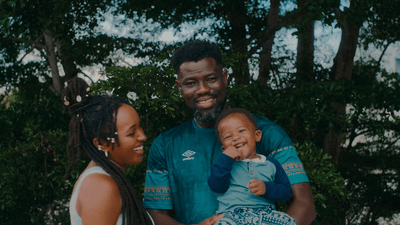 a man and woman holding a baby in their arms