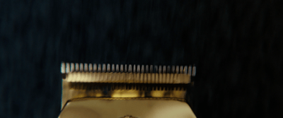 a close up of a gold comb on a mirror