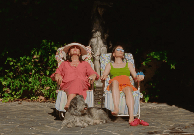 two women sitting in lawn chairs with a dog