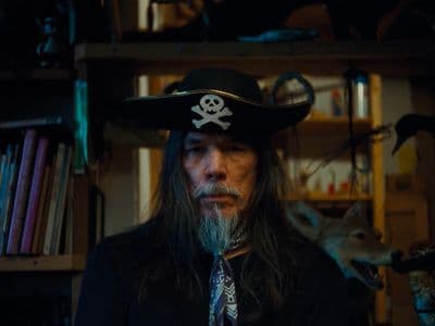 a man wearing a pirate hat and a tie