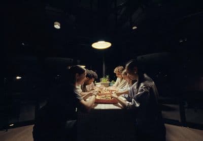 a group of people sitting around a table eating food