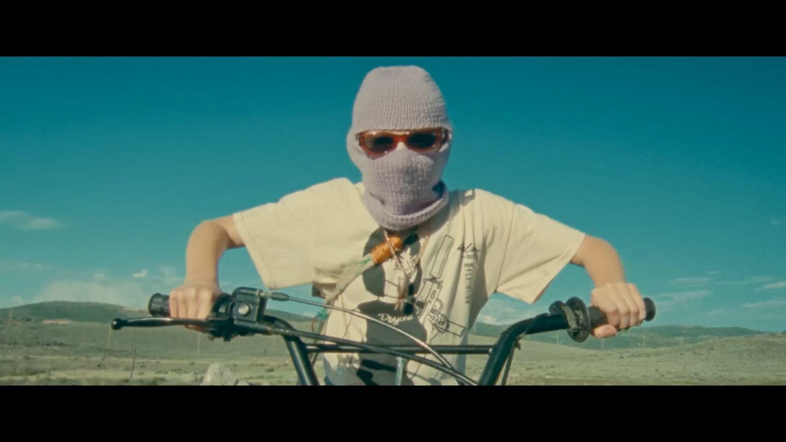 a man wearing a mask riding a bike