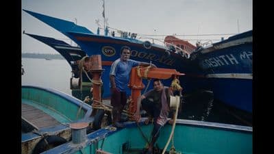 a couple of men standing on top of a boat