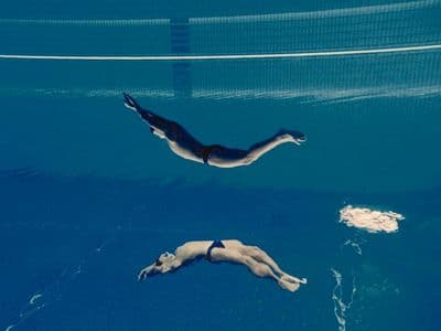 a person swimming in a pool with a net