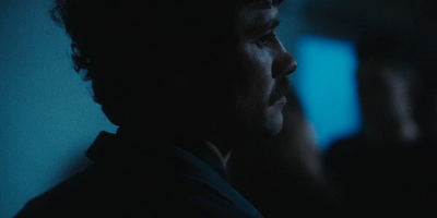 a man in a dark room talking on a cell phone