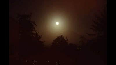 a full moon is seen in the dark sky