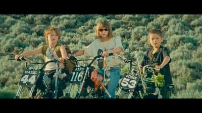 a woman and two children on bikes in a field